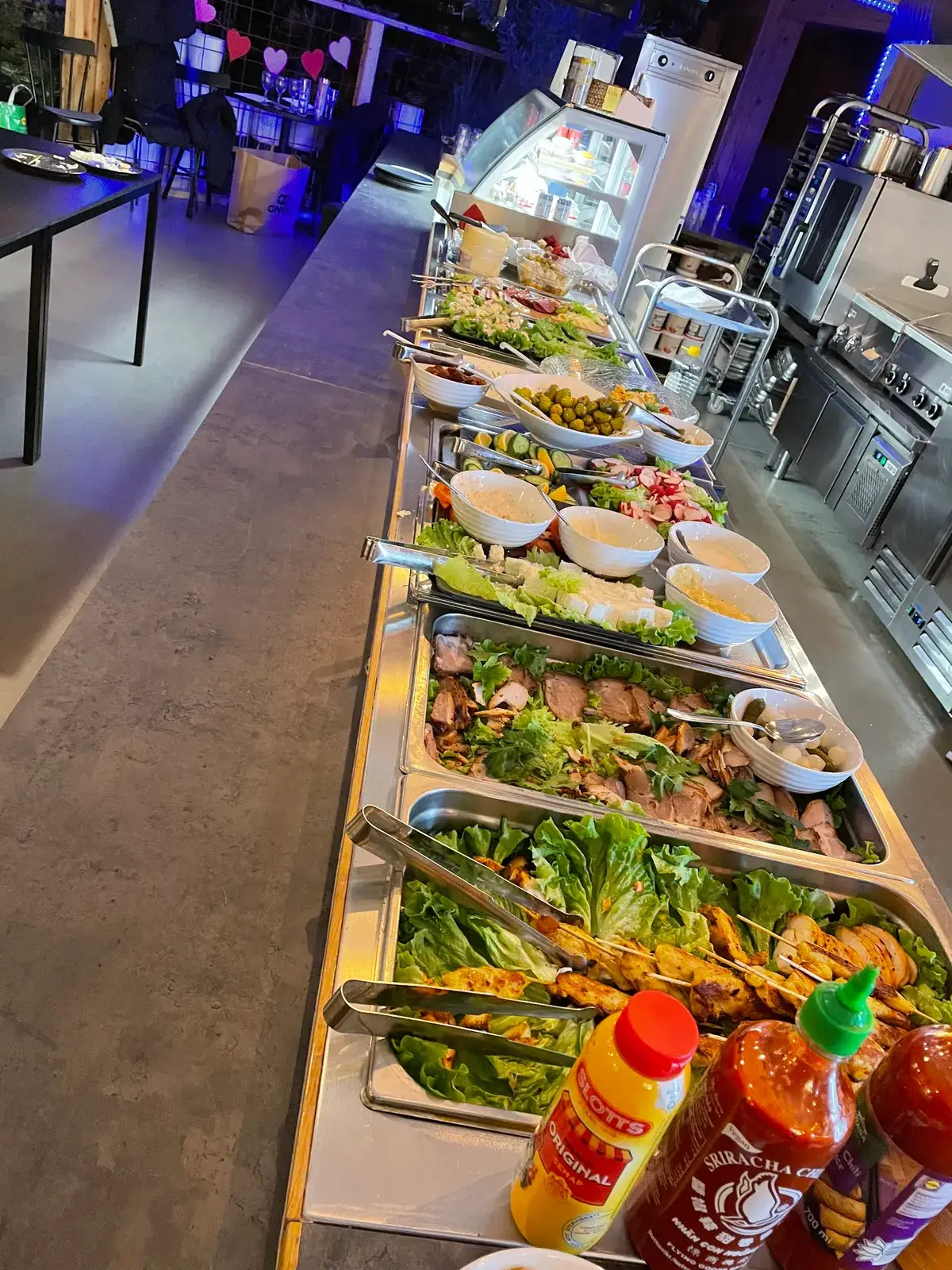 Långt buffébord uppdukat i Emanuels Restaurang med sallader, kött och kyckling